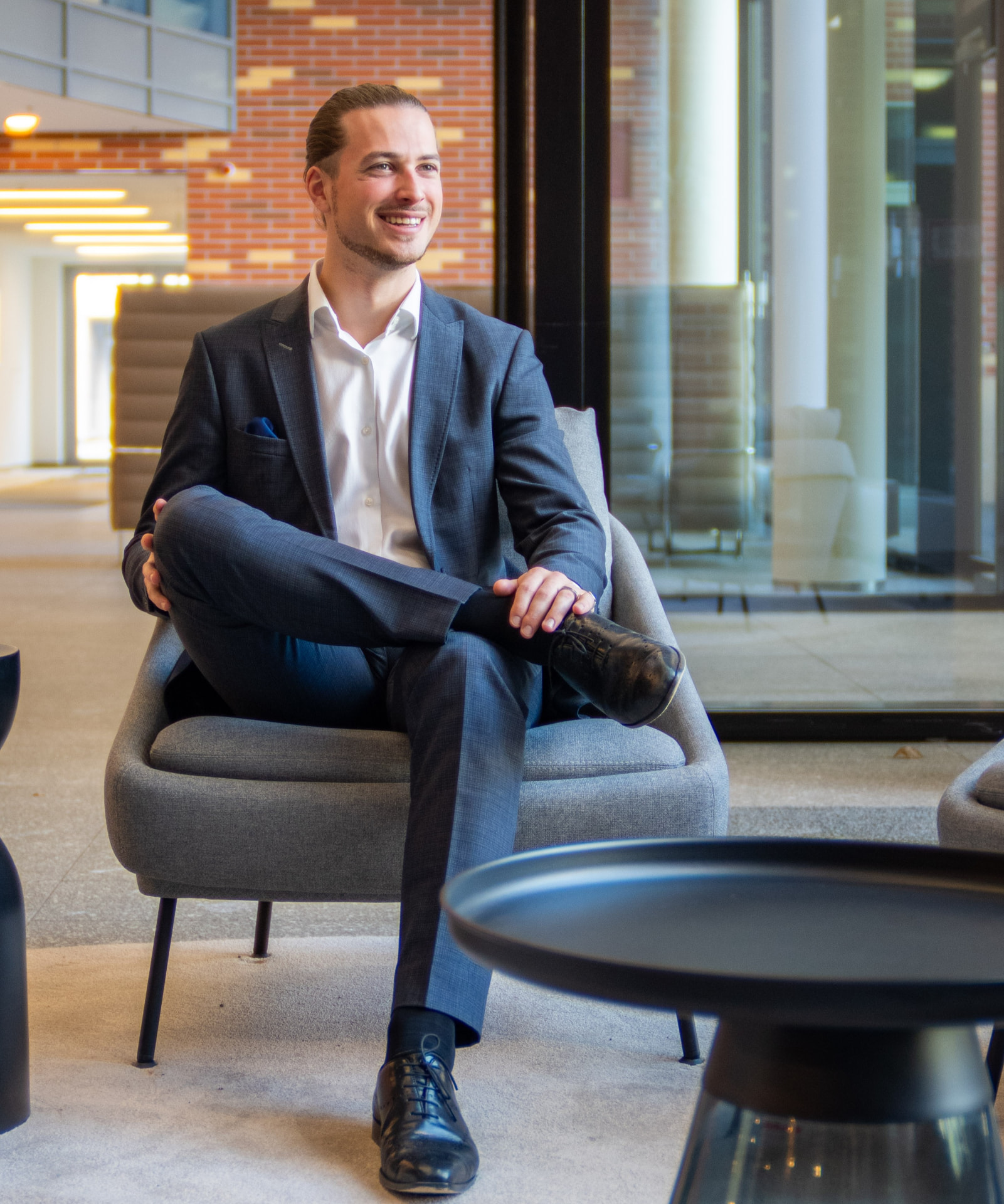 Lucas Breiding sitzend in modernen Praxisräumen im Beratungsgespräch.